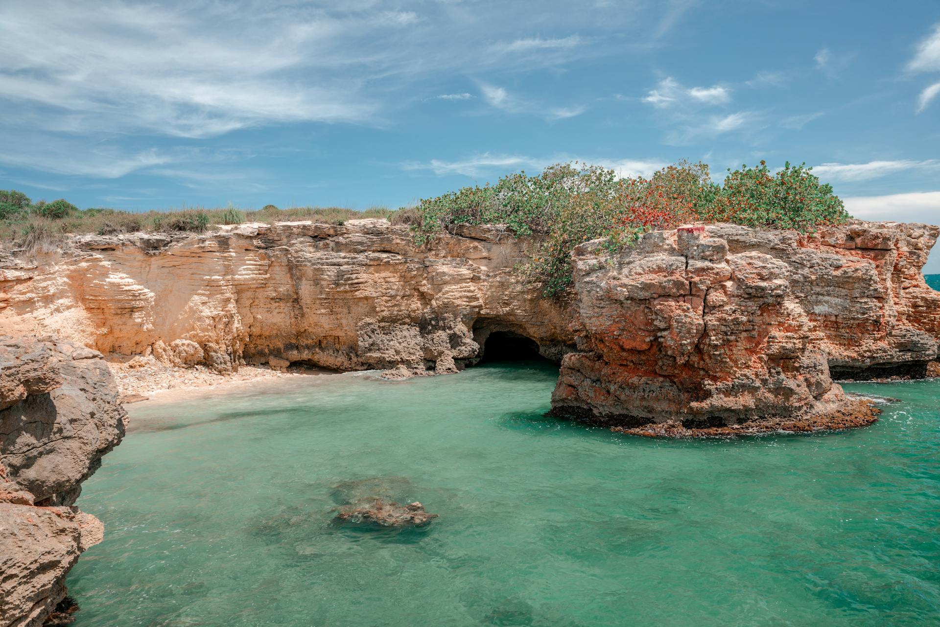 Explore the stunning coastal rock formations and turquoise waters of Cabo Rojo, Puerto Rico under a bright summer sky.