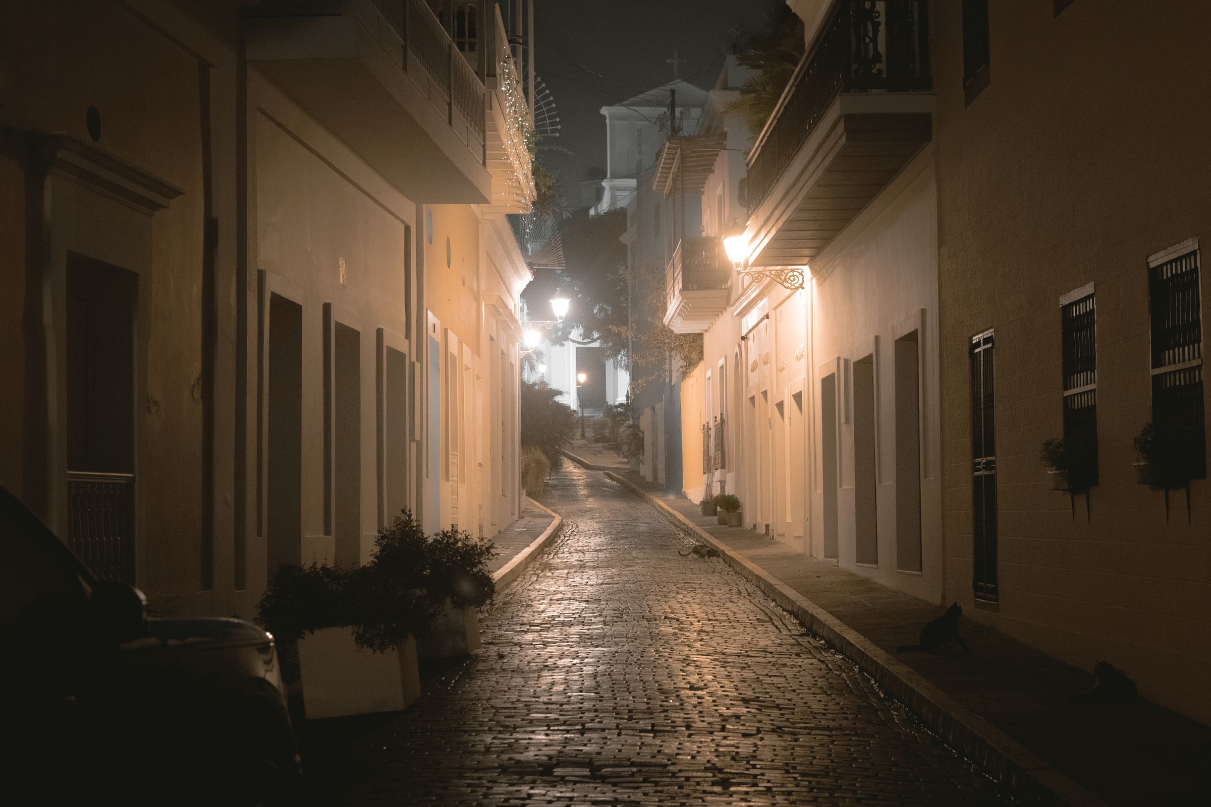A quiet, lantern-lit alley in Old San Juan before dawn