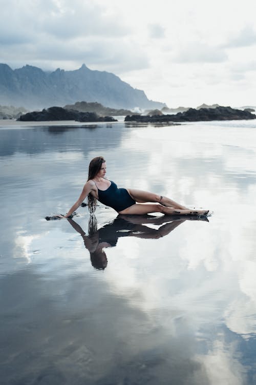 Woman in Swimsuit Lying Down and Posing on Shallow Water on Sea Shore