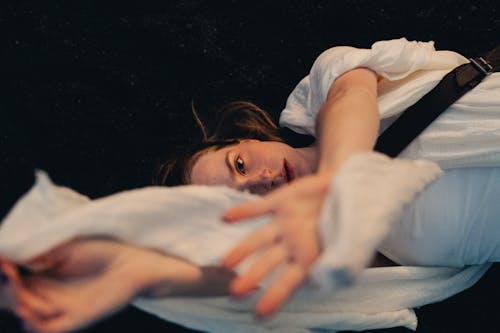Woman Lying Down in White Clothes