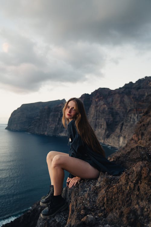 Woman Sitting and Posing on Rocks on Sea Shore