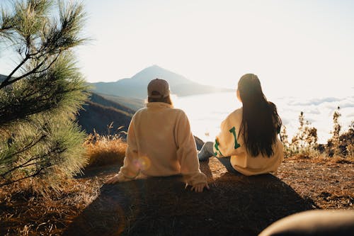 Women Sitting on Hilltop with Clouds below