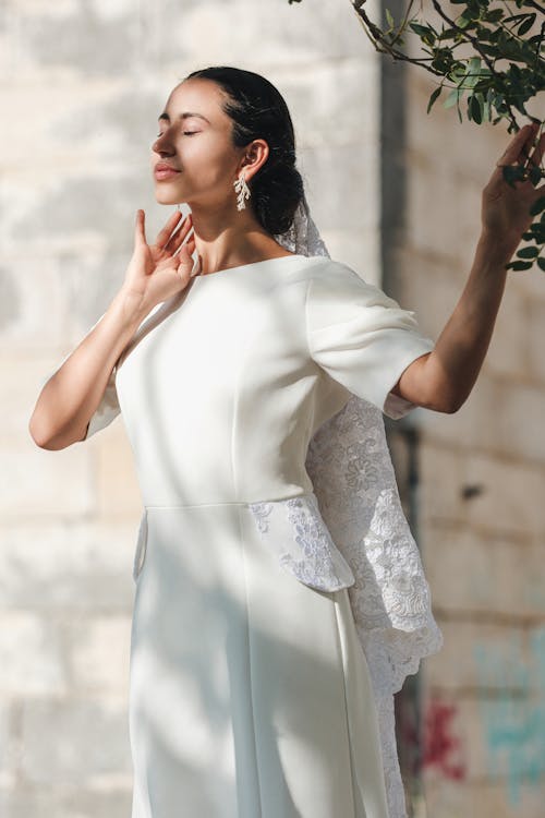 Woman Standing in Wedding Dress with Eyes Closed