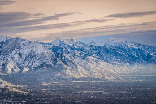 Free A breathtaking aerial view of a snowy mountain range with a valley below during winter. Stock Photo