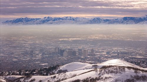 Snowy aerial view of the Salt Lake valley in Utah with the Wasatch Mountains rising behind the city
