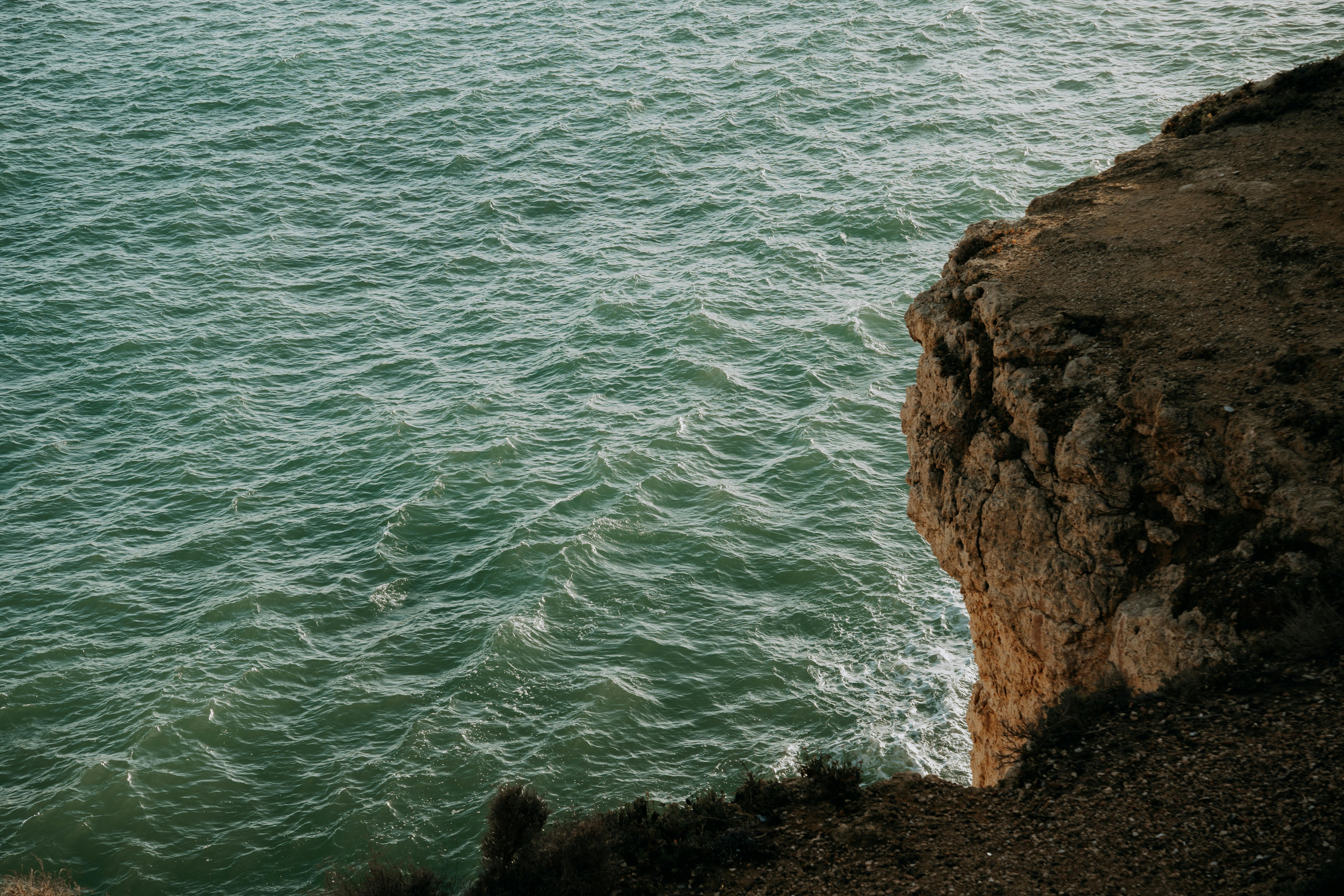 High-angle view of a rocky cliff and vast sea in Torredembarra, highlighting the natural beauty of the Spanish coastline.