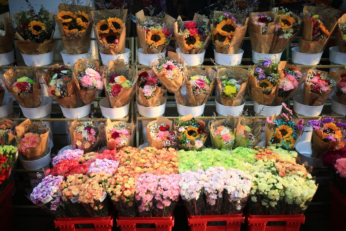 Rows of sunny mixed bouquets in kraft wrap.
