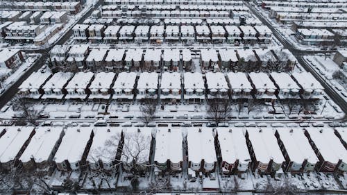 Drone Shot of Rows of Houses with Roofs Covered in Snow 