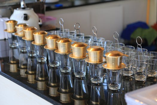 Elegant rows of traditional coffee makers on a café countertop in Bangkok, Thailand.