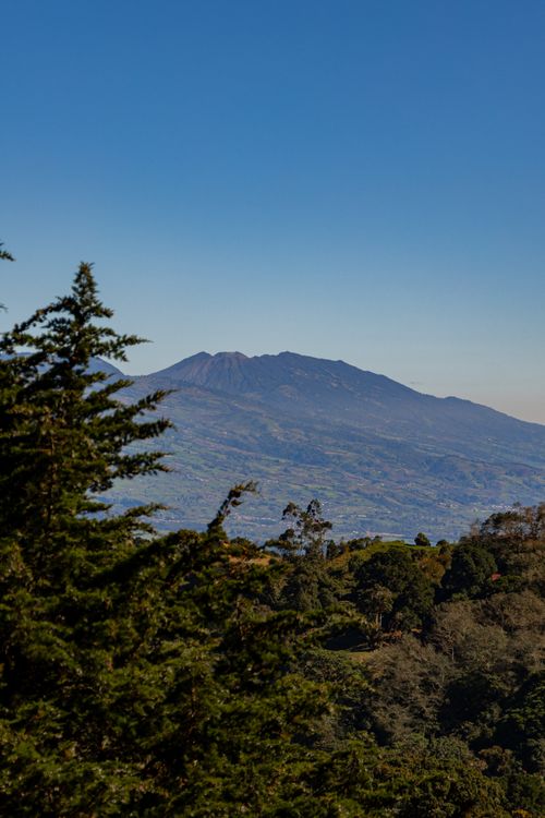 Free Aerial view of lush forest and mountain under clear blue sky in Costa Rica. Stock Photo