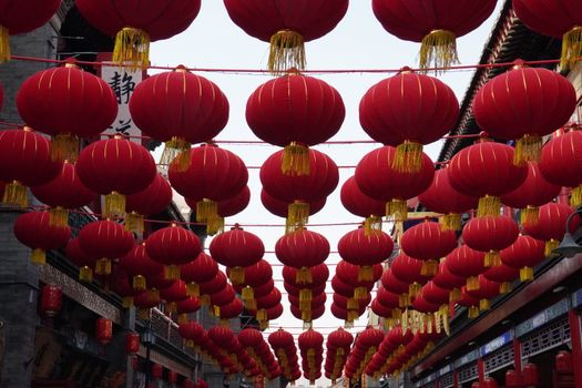 A vibrant display of red Chinese lanterns hanging in a traditional street, celebrating Chinese culture.