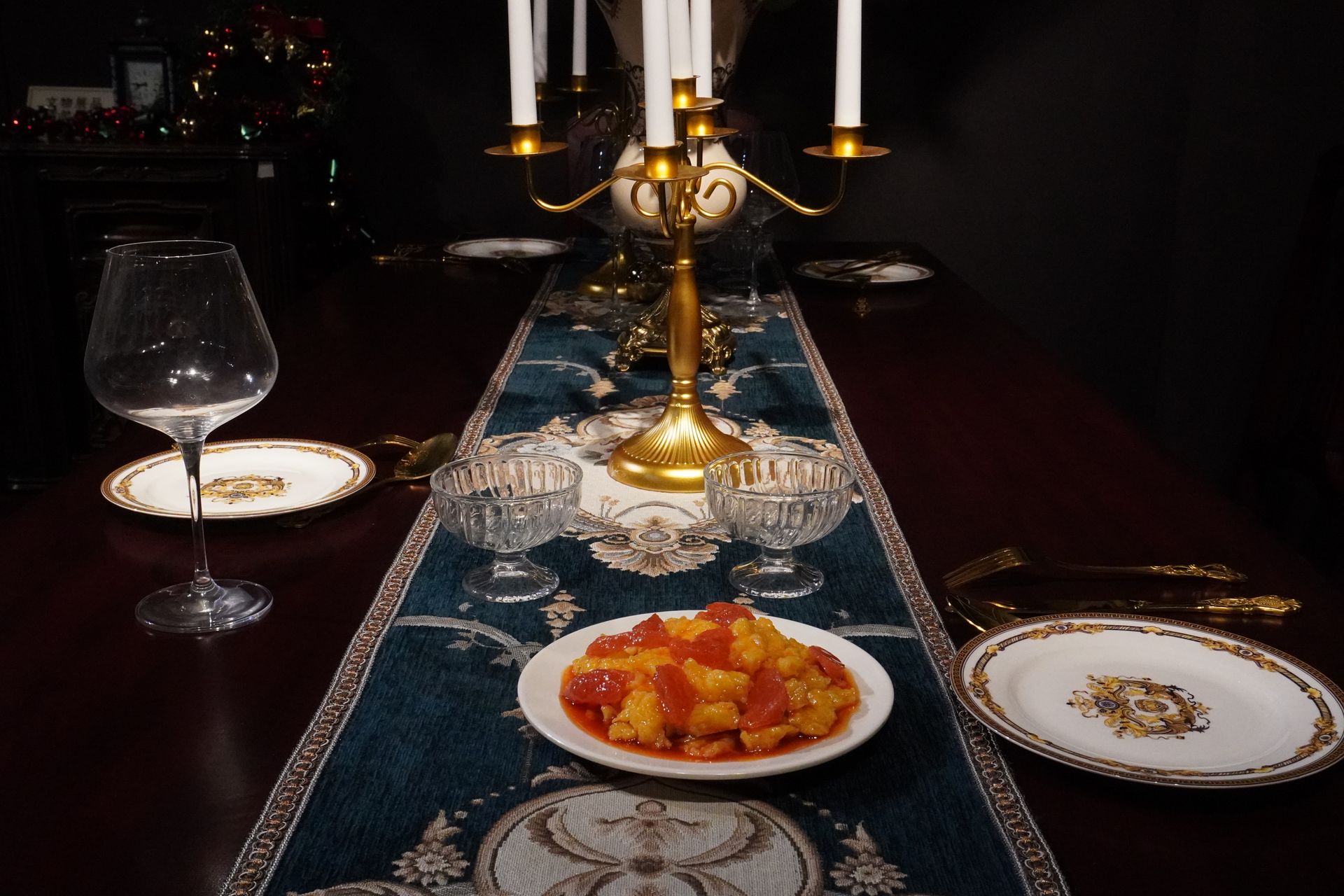 Luxurious dining table with vintage decor, glassware, and a candlestick centerpiece.