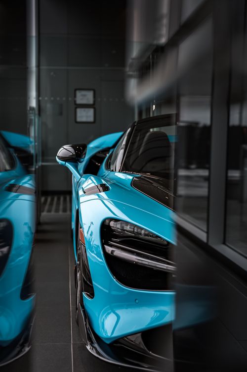 Free Close-up of a blue supercar reflecting in glass with a sleek design. Stock Photo