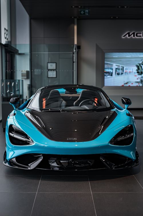 Free Luxurious blue sports car highlighted in a modern showroom, showcasing elegance and speed. Stock Photo