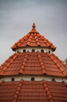 Close-up of a red tiled roof showcasing traditional architectural design with intricate details.