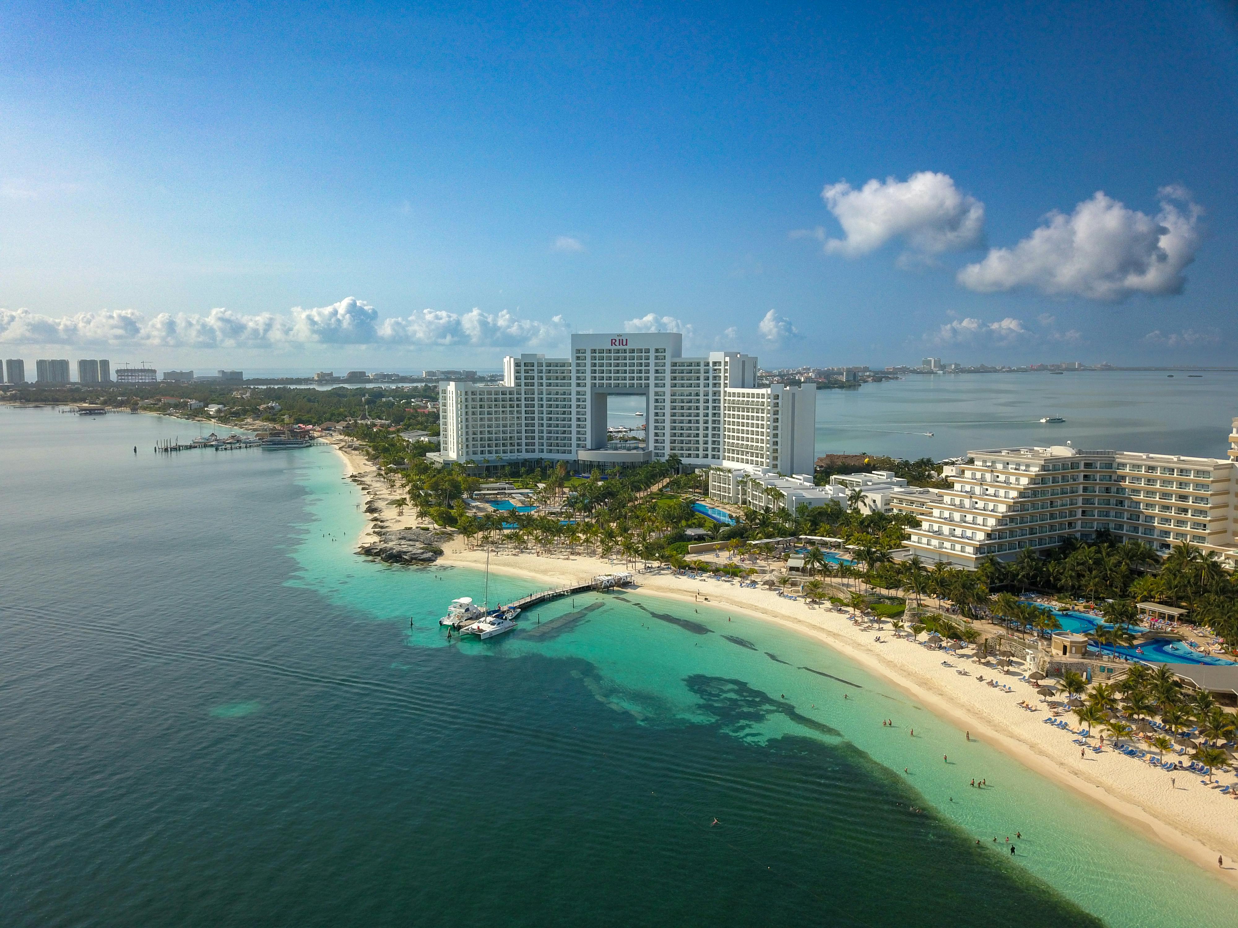 A stunning aerial view of a hotel on the Cancún beachfront, showcasing the coastline and sea.