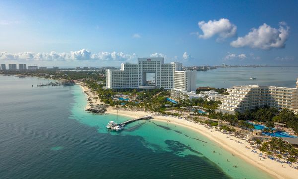 A stunning aerial view of a hotel on the Cancún beachfront, showcasing the coastline and sea.
