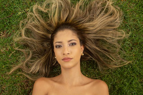 Top View of Blonde Woman Lying Down on Grass