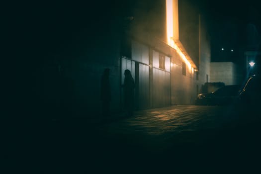 Eerie silhouettes in a foggy alleyway in Ankara, captured at night.