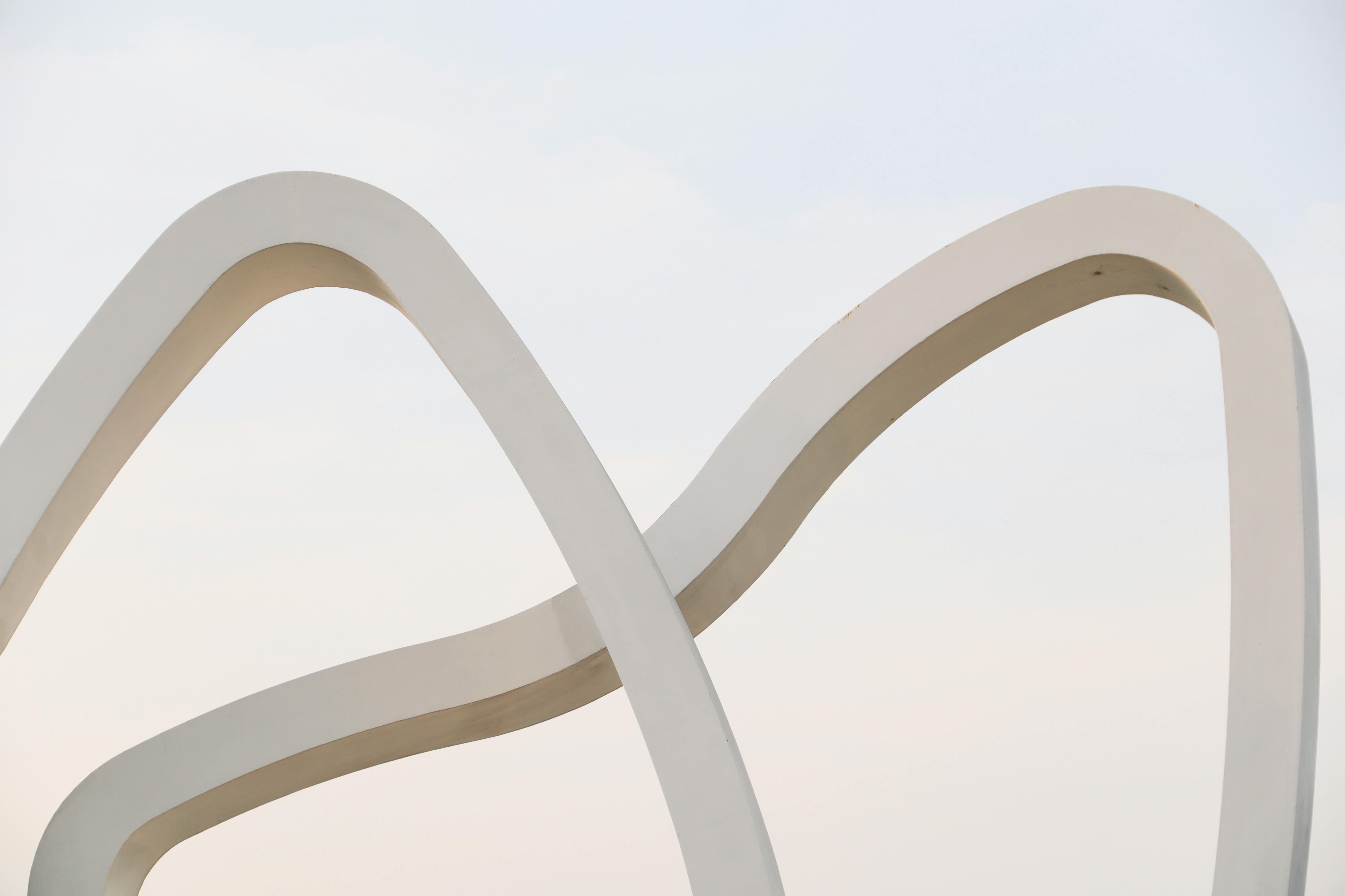 A modern abstract sculpture set against a clear sky, showcasing minimalistic and contemporary design.