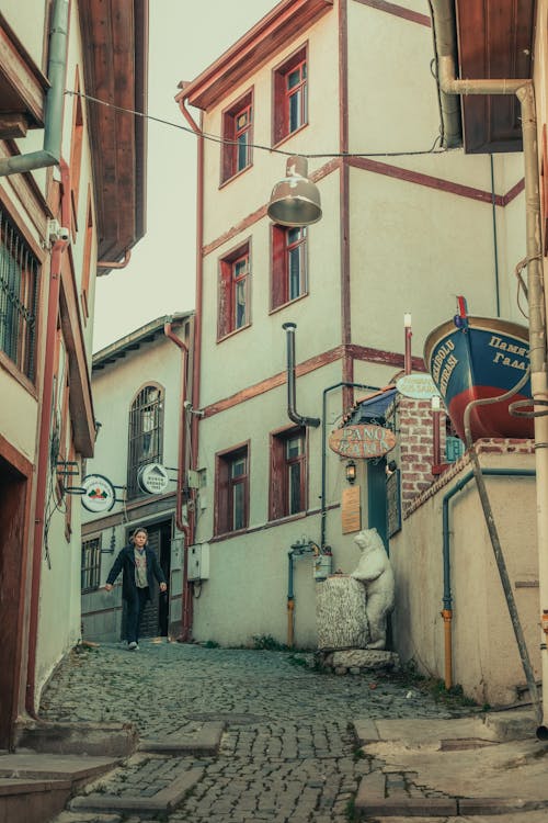 A Pedestrian Walking Down a Narrow Alley between Houses in a Turkish Town 