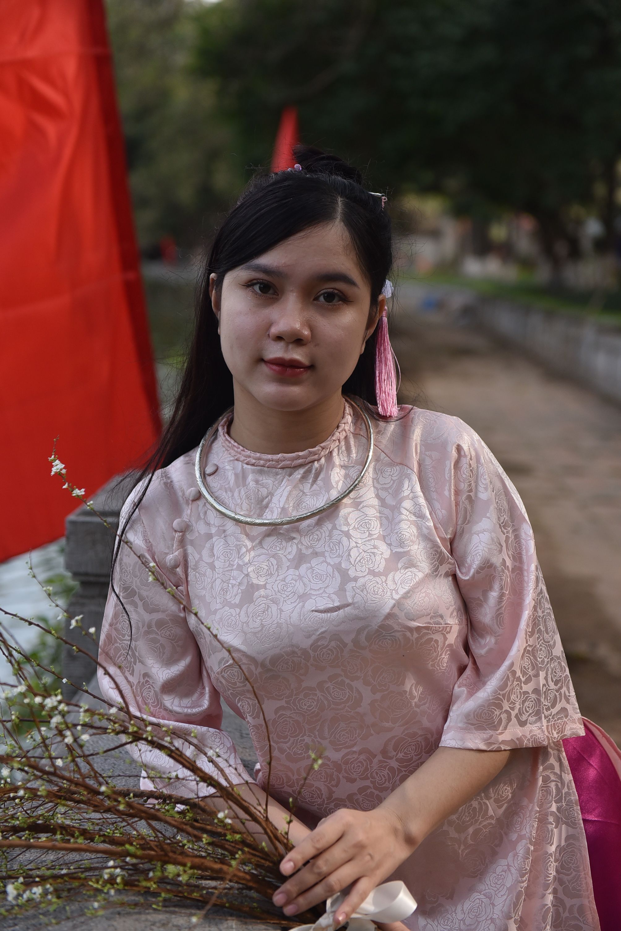 A woman in a pink dress holding a red flower · Free Stock Photo