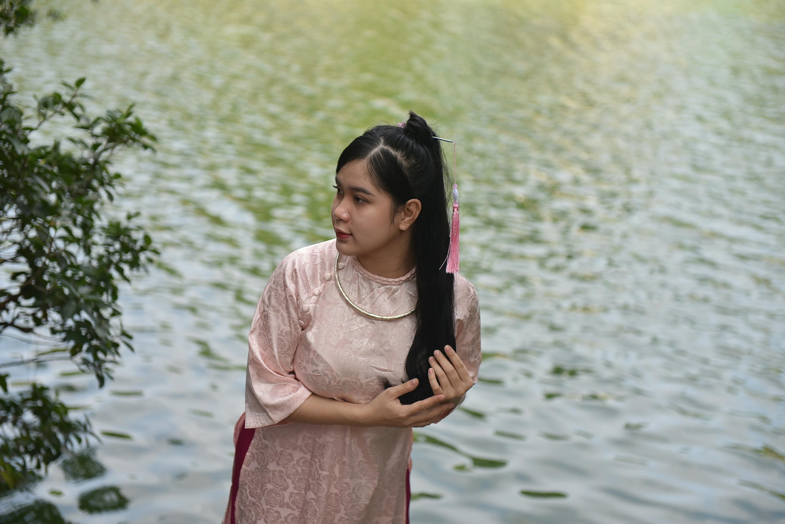 Woman Smiling While Standing Near Body of Water · Free Stock Photo