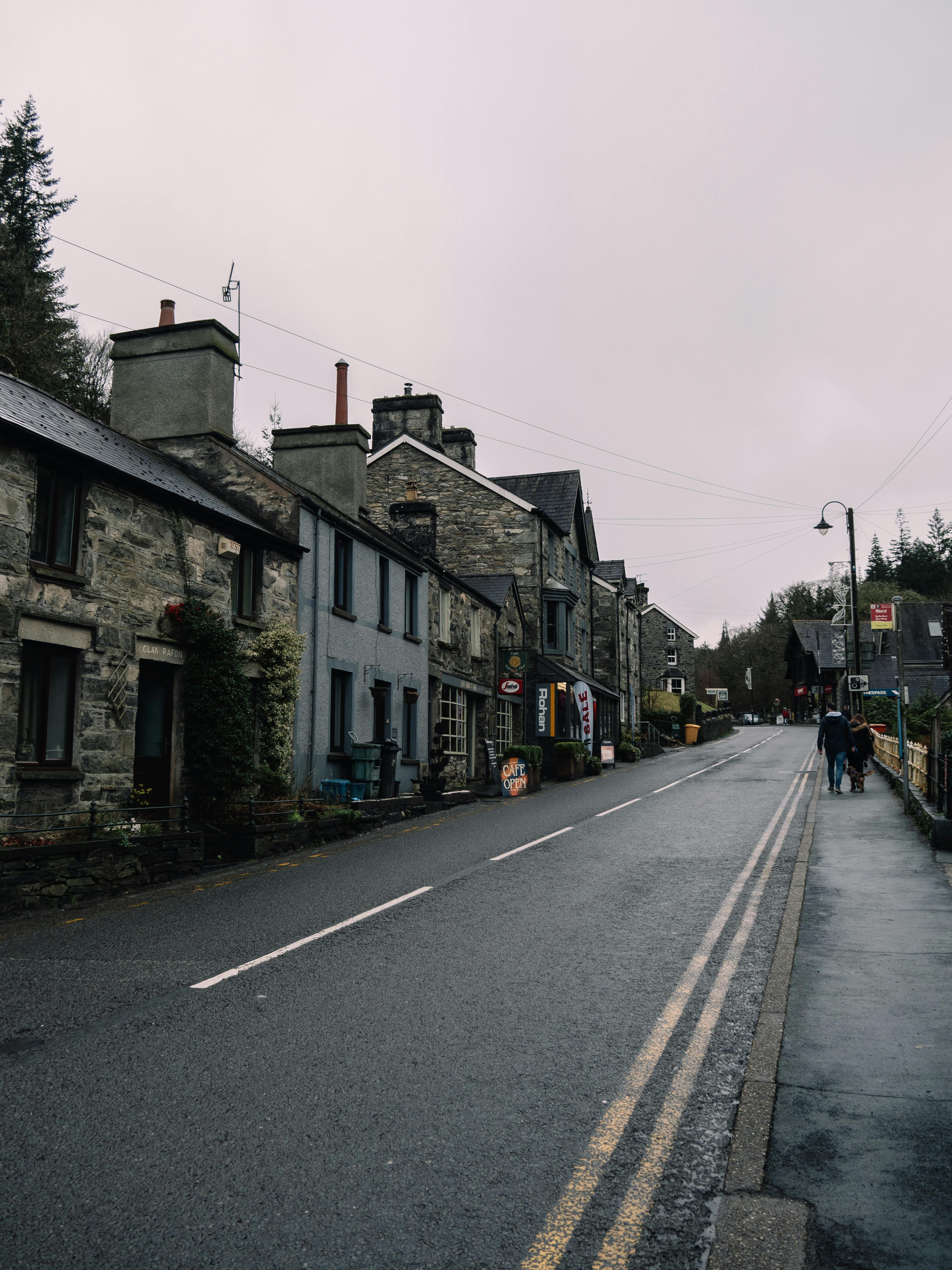Quaint village street lined with stone buildings and overcast sky, creating a historic ambiance.