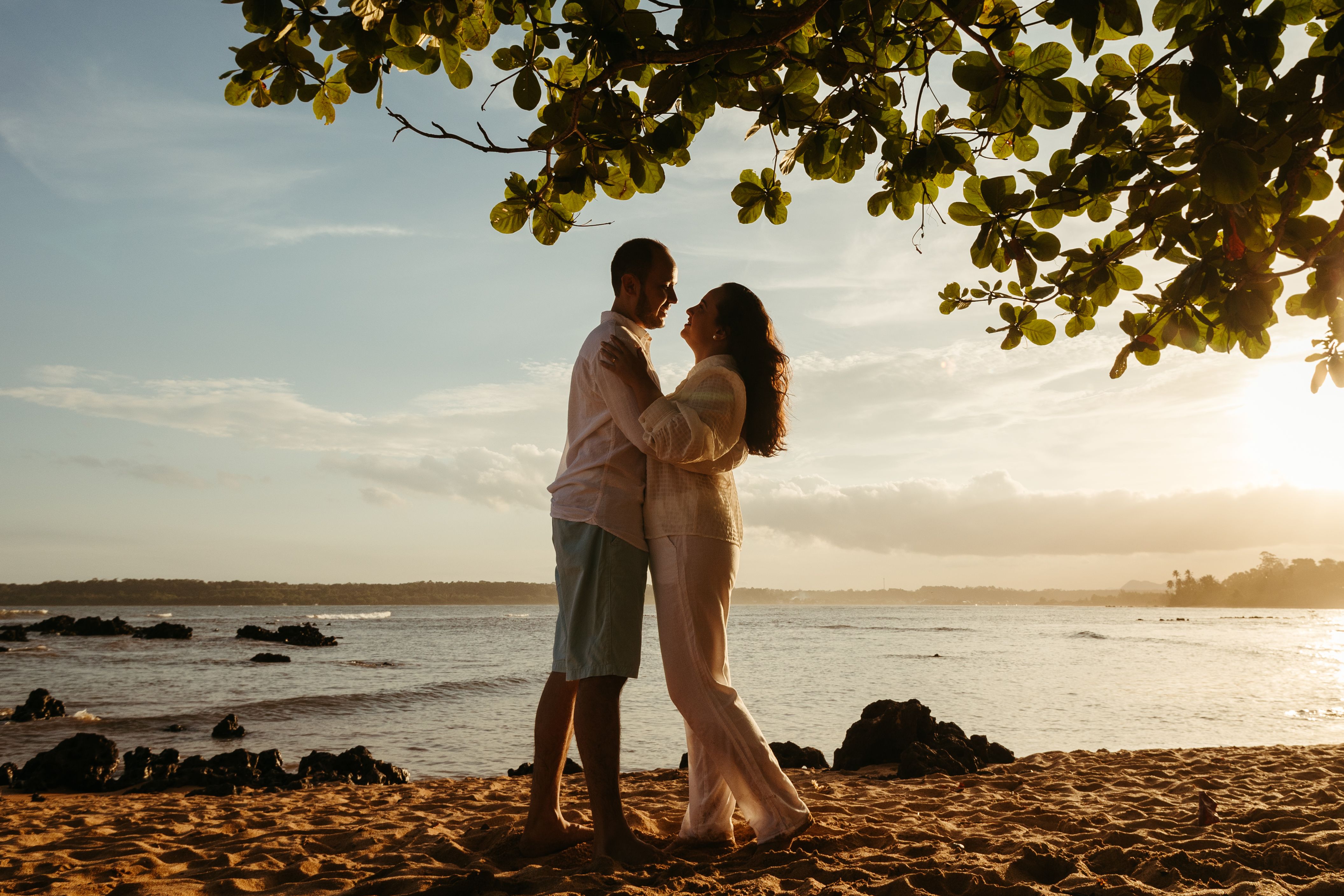 A couple standing on the beach at sunset · Free Stock Photo