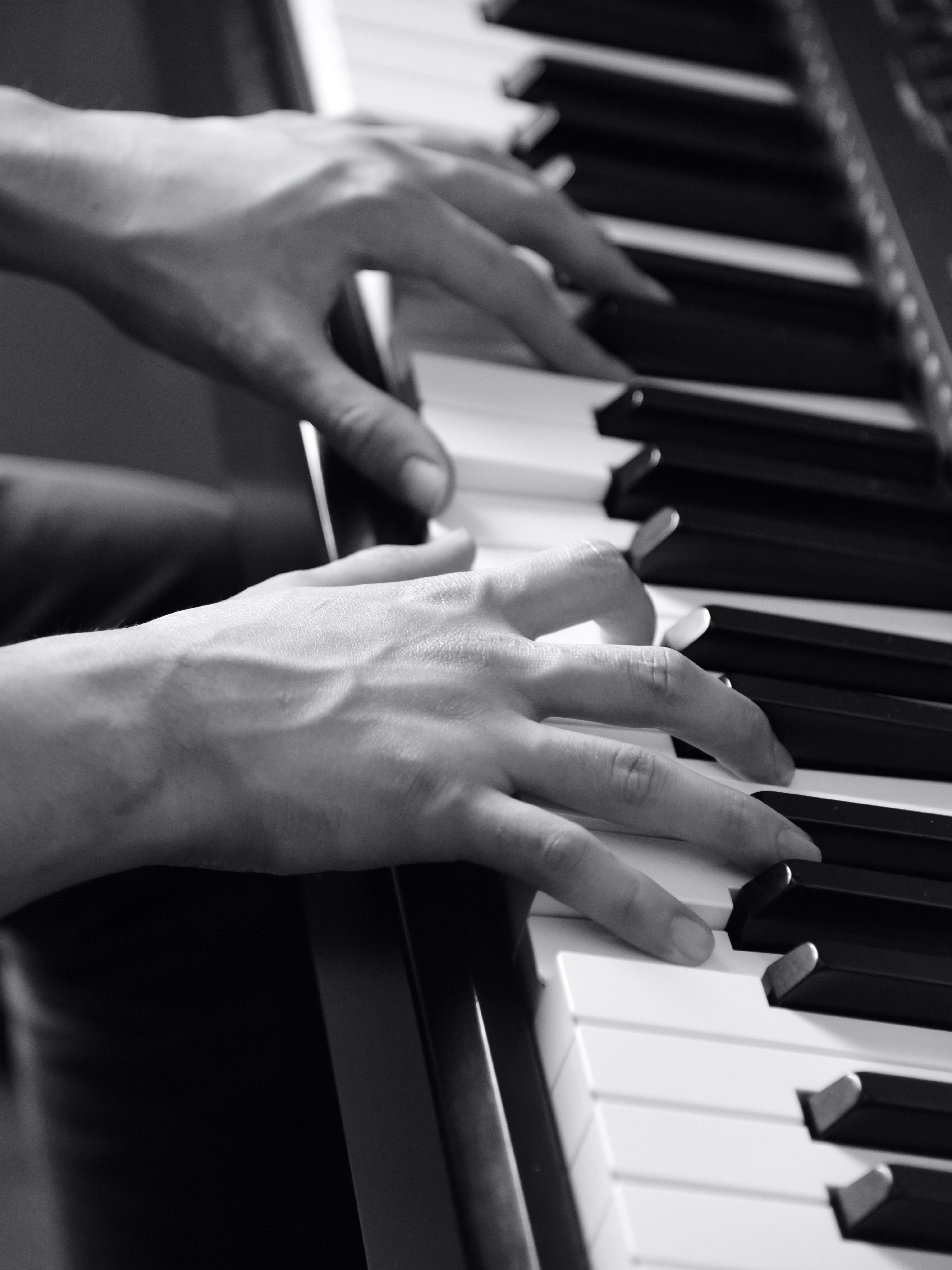 A pianist rehearsing at a grand piano in black and white