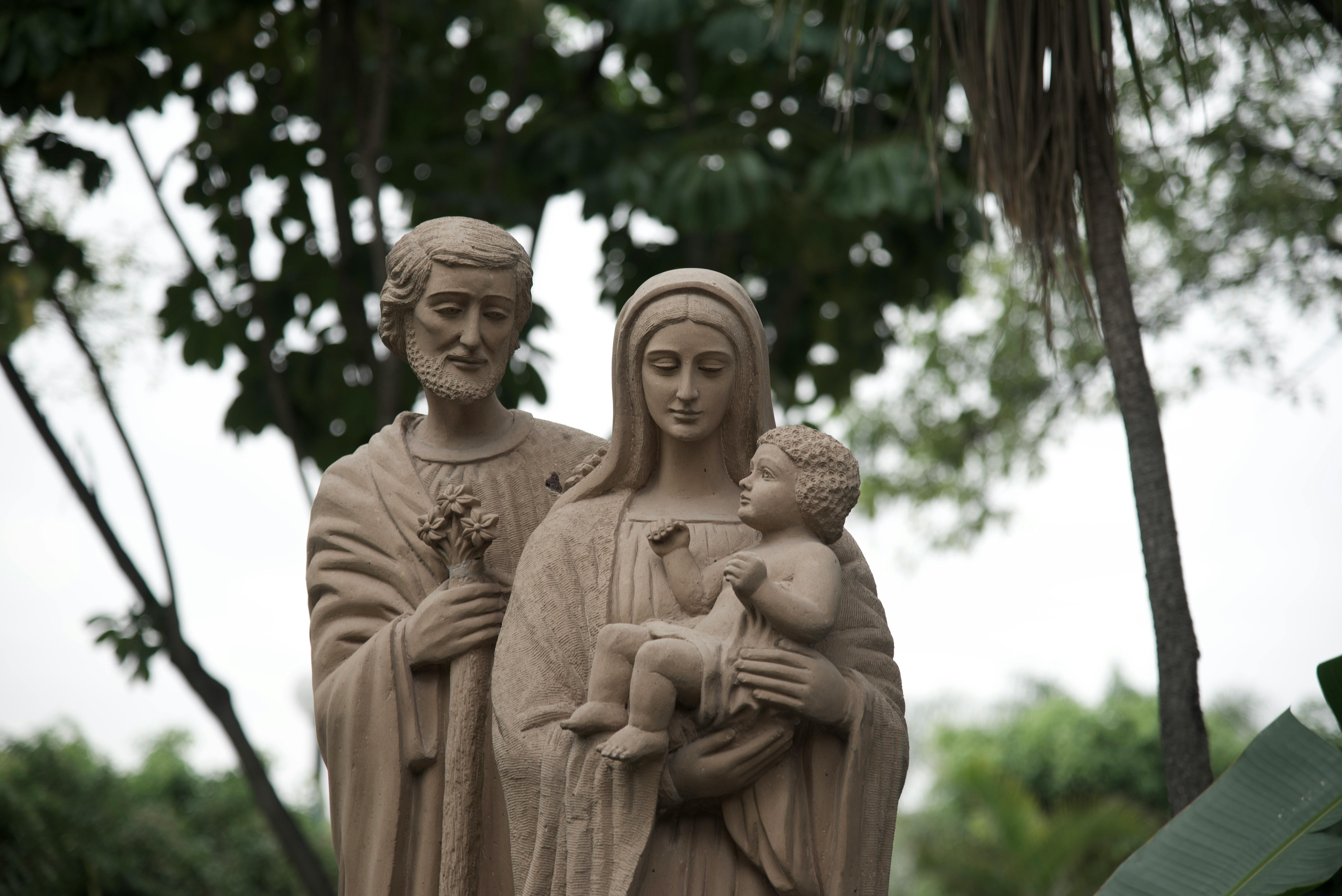 Sculpture of Saint Joseph, Virgin Mary, and Jesus outdoors.