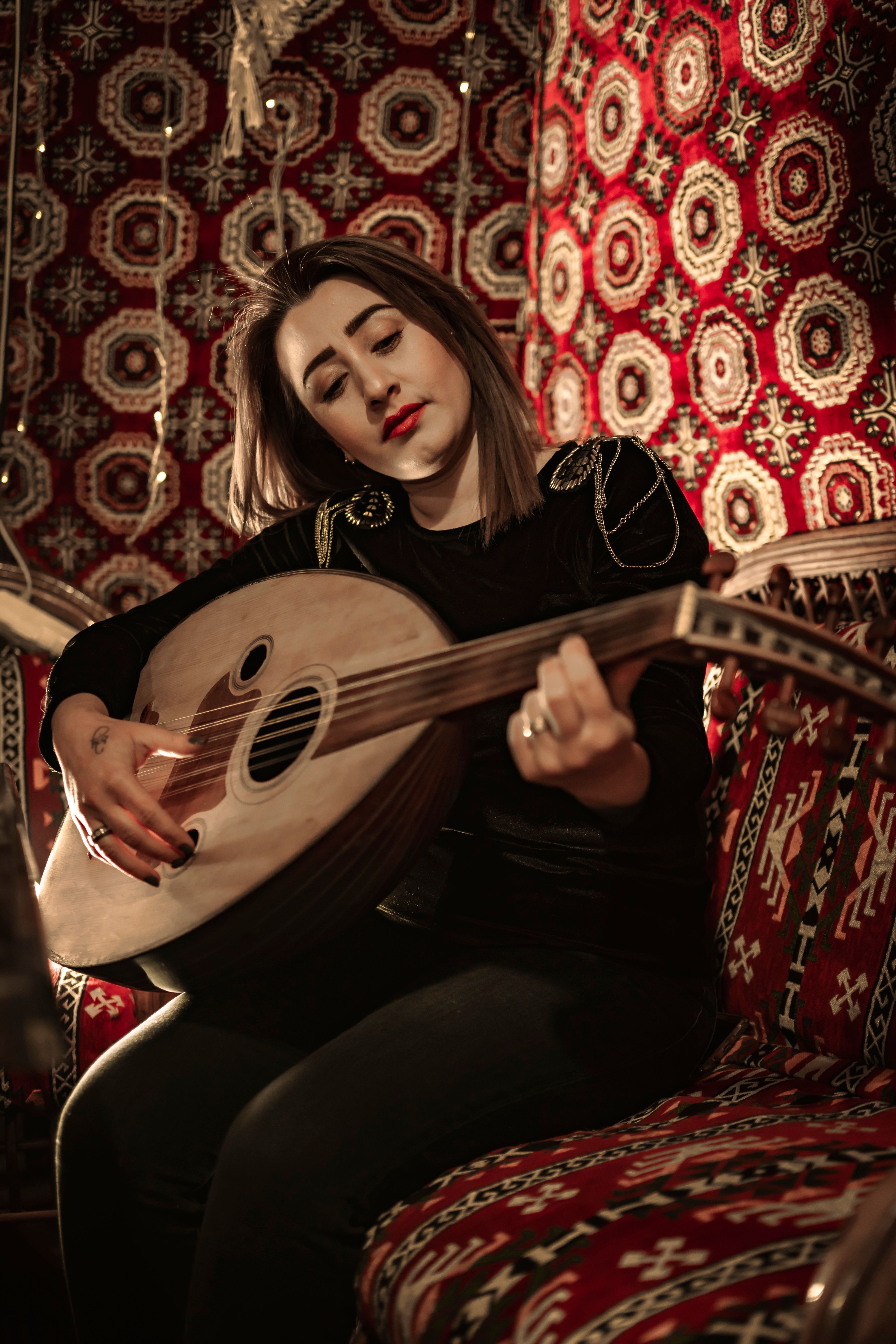 A woman plays the oud in a richly decorated Turkish interior, showcasing cultural elegance.