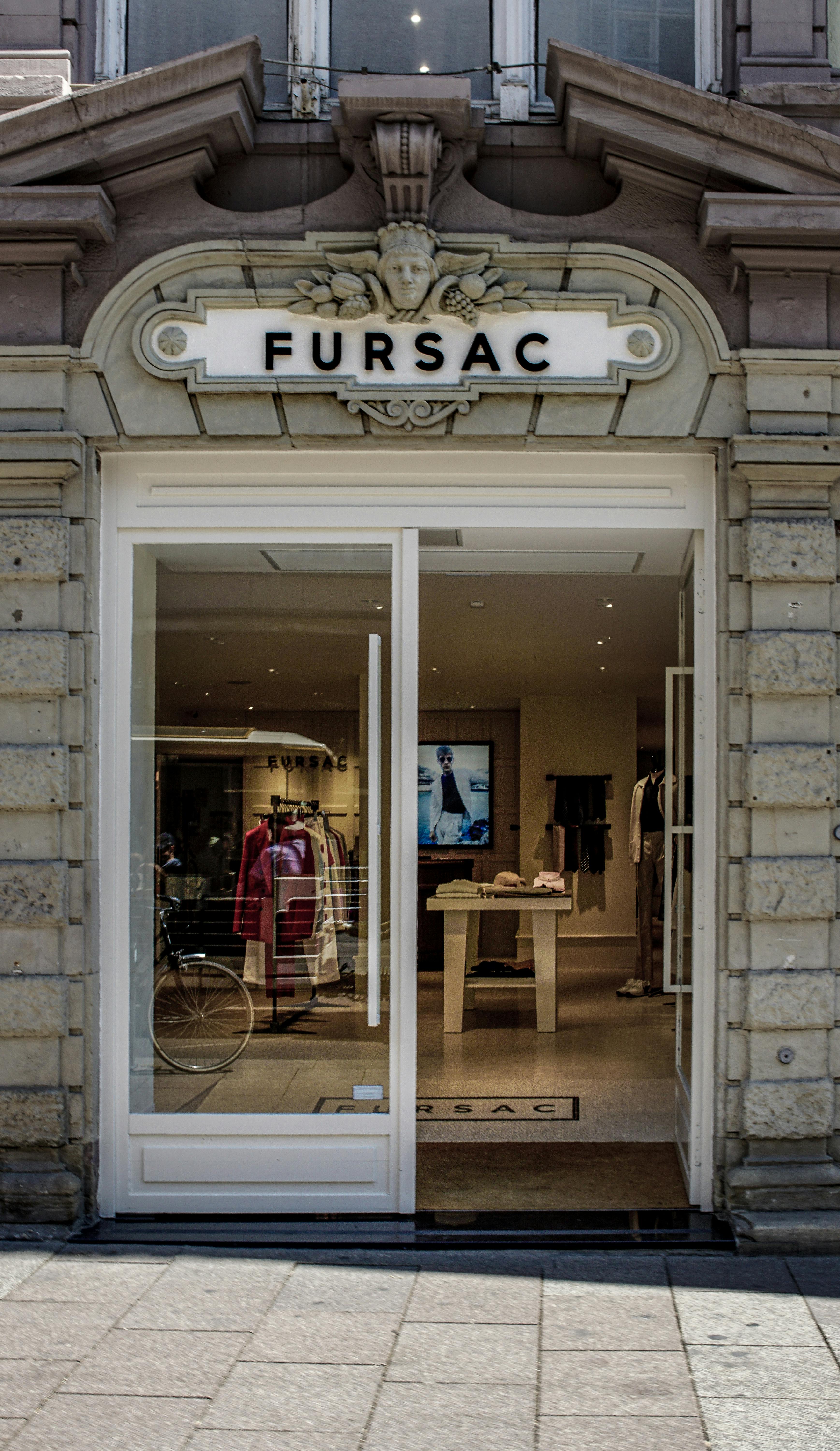 A stylish entrance to a luxury clothing store featuring elegant architecture and fashion displays.