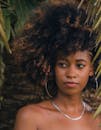 在自然的户外环境中，一位留着浓密非洲发型的女性肖像令人惊叹
