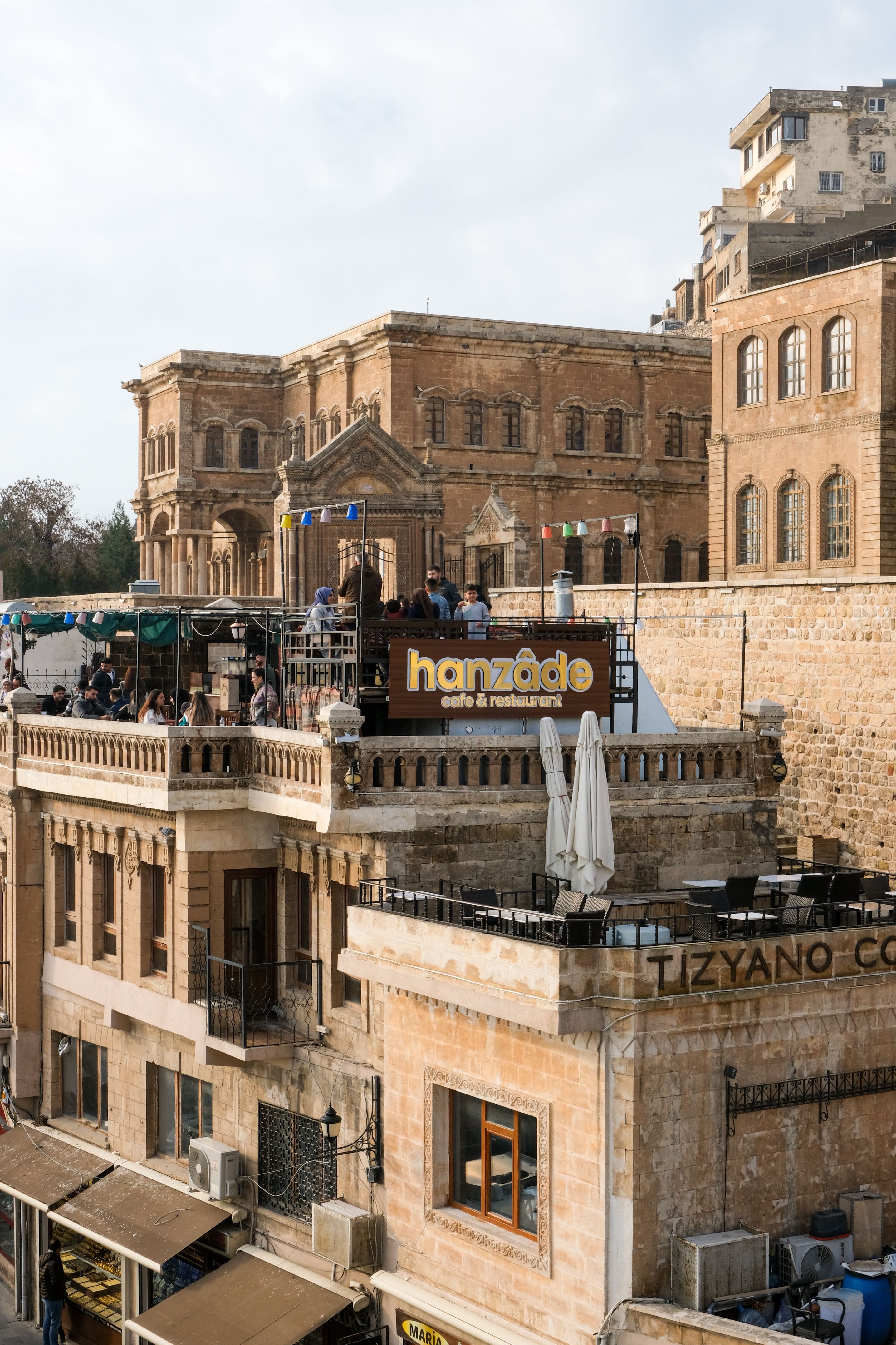 Explore the historic architecture and vibrant atmosphere of Mardin's rooftop scene in summer.