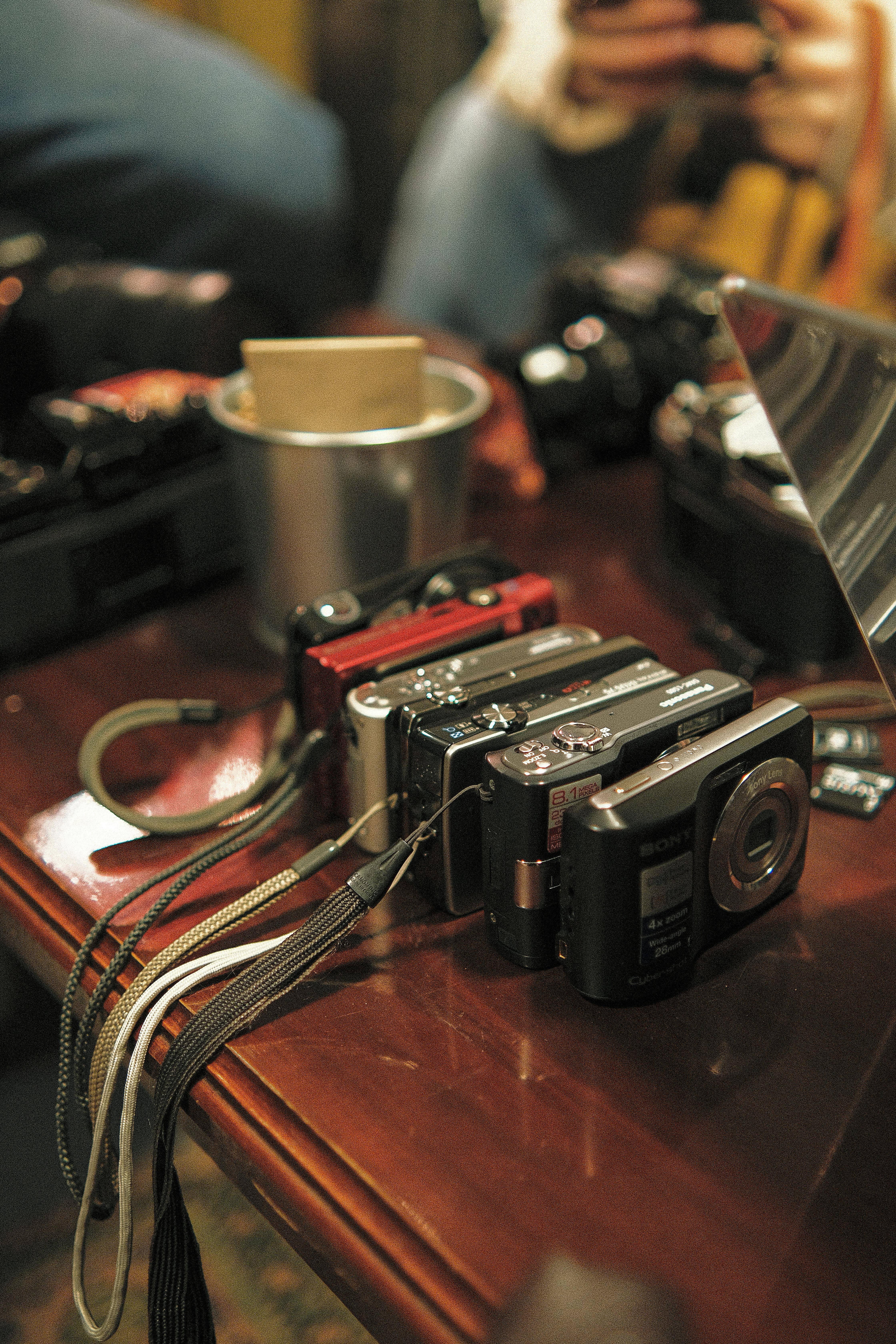 a bunch of digital cameras standing on a table