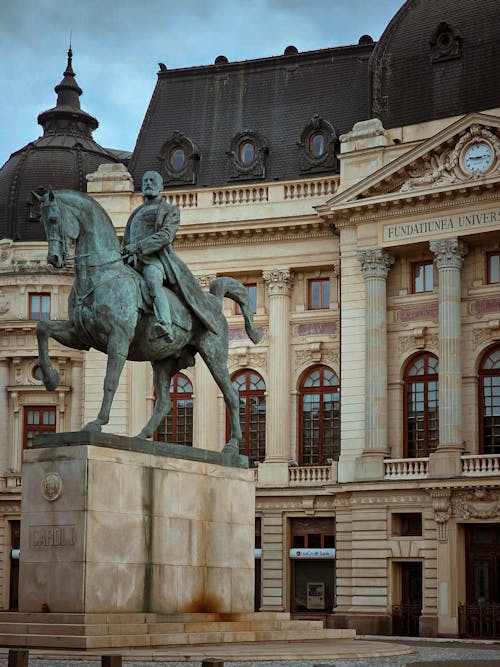 A statue of a man on a horse in front of a building