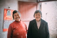Two Elderly Women Standing Together and Smiling