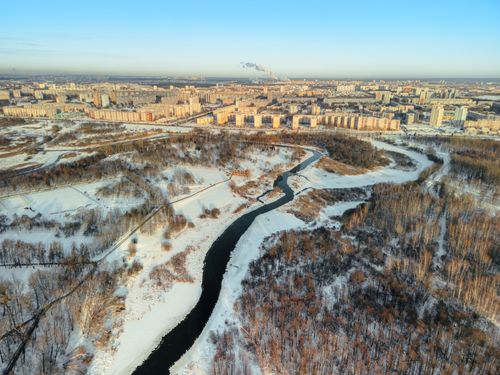 Free Aerial view of winter landscape in Minsk, showcasing snow-covered cityscape and winding river. Stock Photo