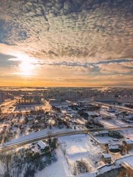 Stunning aerial view of Minsk, Belarus in winter at sunrise, showcasing snow-covered urban landscape.