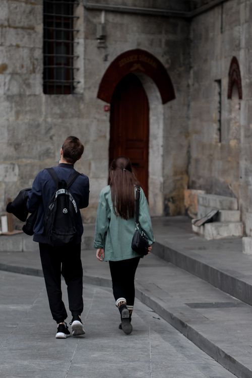 Free Young couple walking past historic mosque entrance in Istanbul, Turkey. Stock Photo