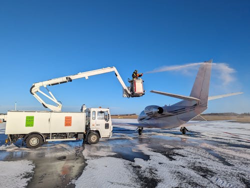 Airport Vehicle Spraying an Airplane with Water