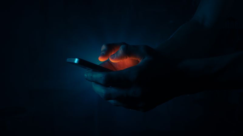 Hands lit by a phone screen by Jaroslav Maler on Pexels