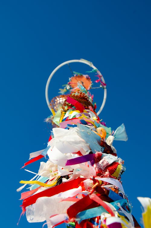 A tall pole with many colorful ribbons on it