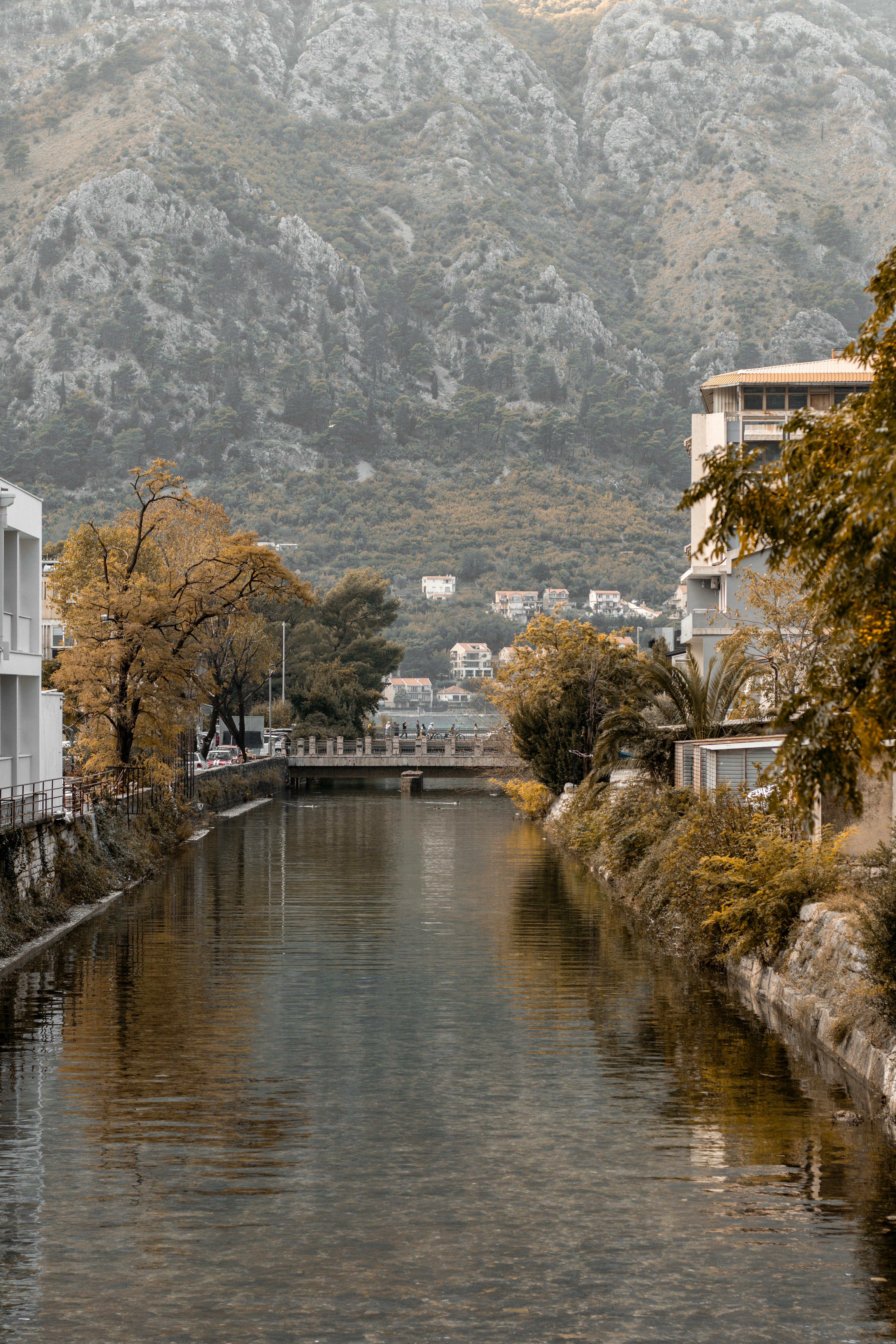 a river in the city with mountains in the background