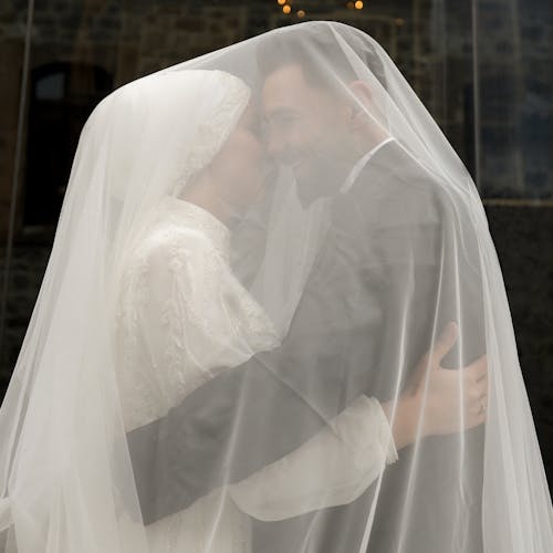 Smiling Newlywed Couple under Veil