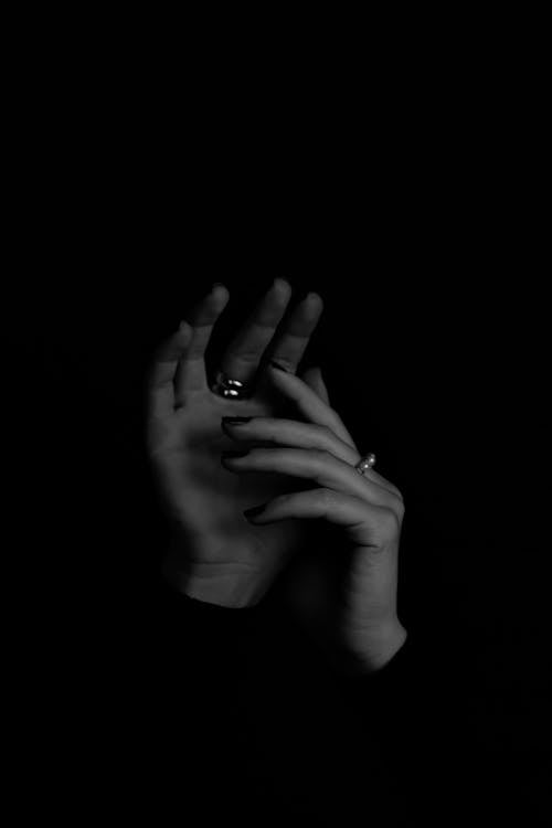 Woman Hands with Rings in Darkness