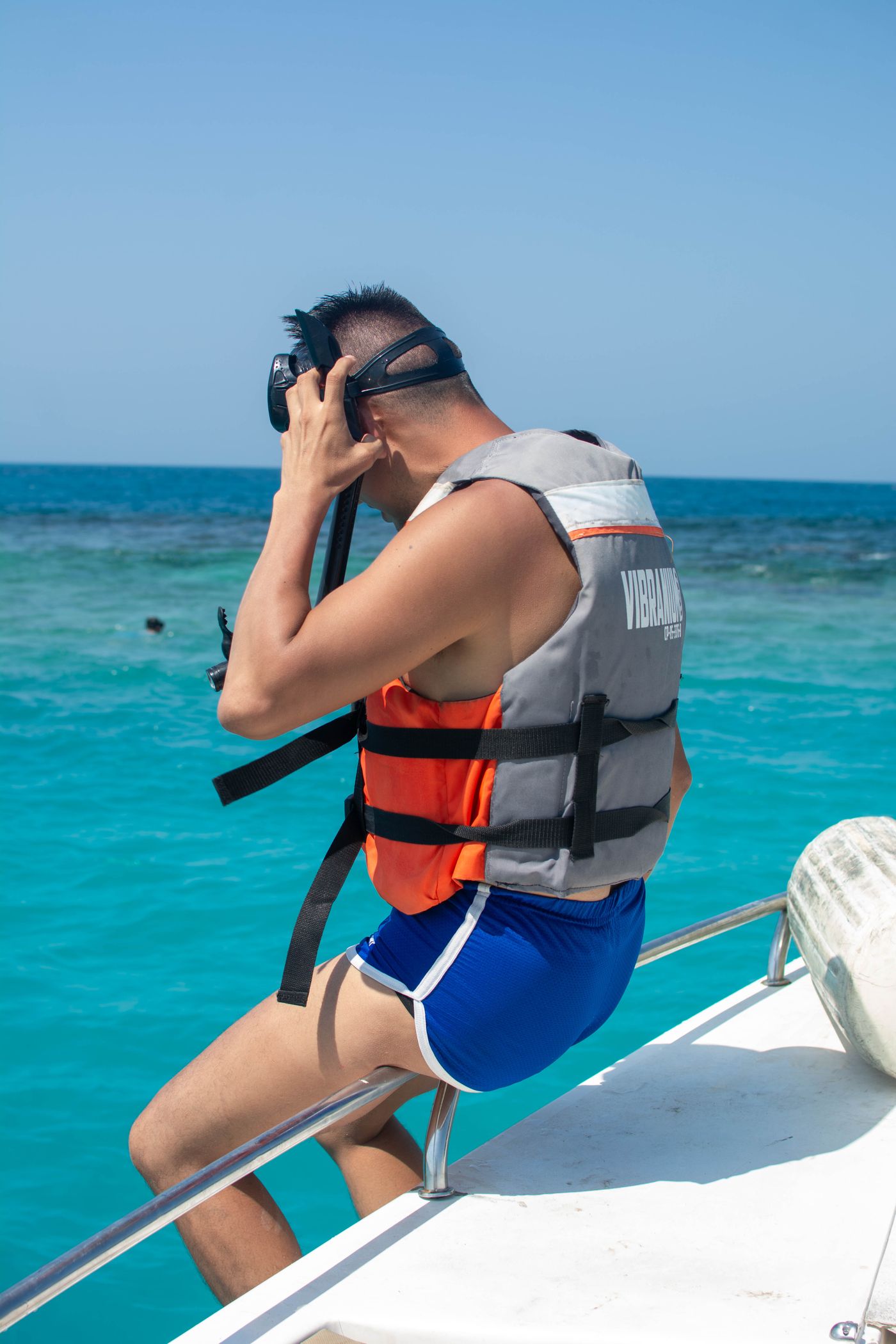 Man wearing a life jacket with snorkeling gear on a boat