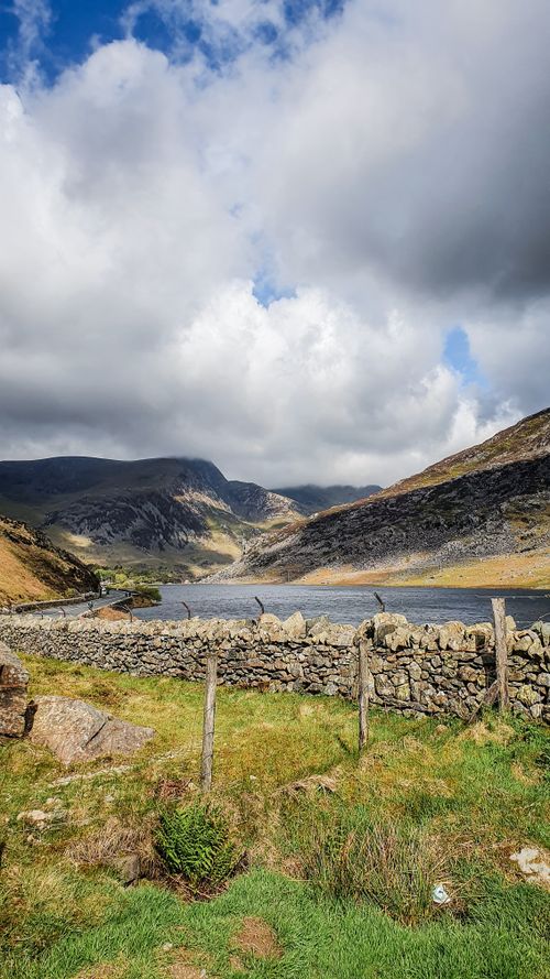 Free A picturesque view of a mountain valley and stone wall in Wales. Stock Photo