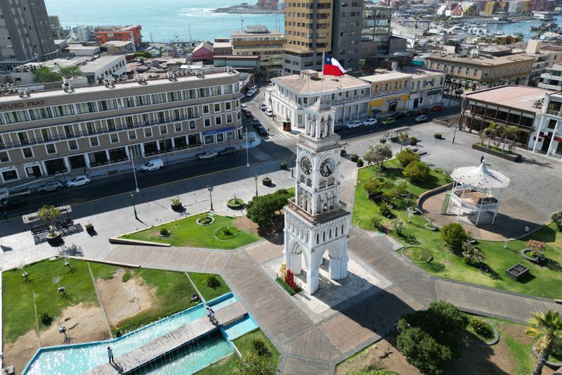 A stunning aerial view of the Clock Tower in Plaza Prat, Iquique, Chile, showcasing urban architecture and coastal beauty.
